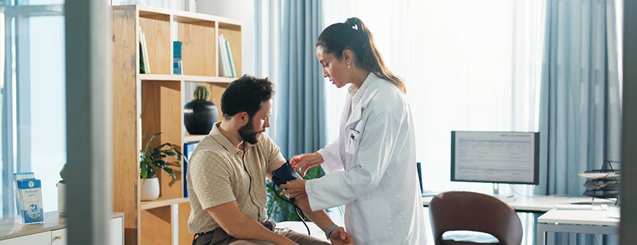 Image of male patient getting his blood pressure tested by a female physician